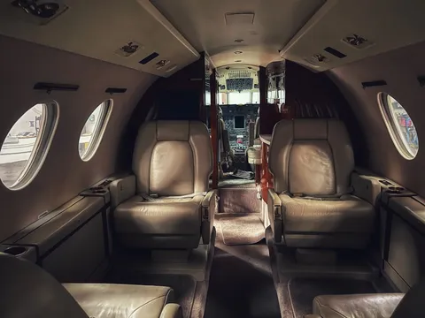A business jet cabin with cream leather seats