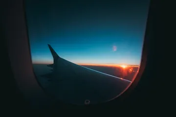 A wing at sunset seen through a cabin window